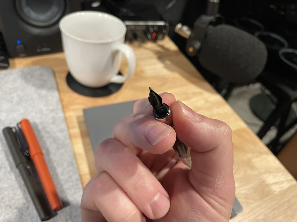 the bottom view holding a fountain pen